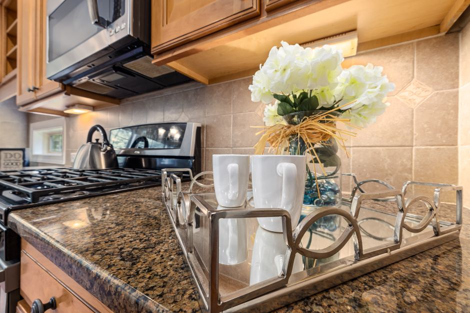 Contemporary kitchen with granite countertops, stainless steel appliances, and decorative elements.